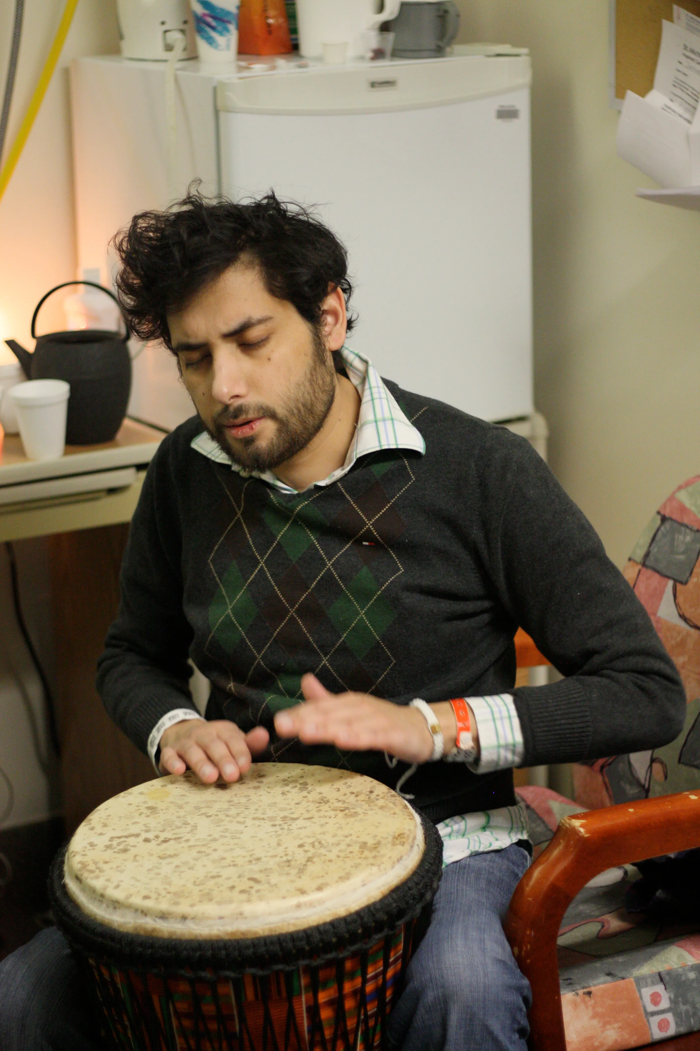 Jehangir playing a hand drum in a hospital room
